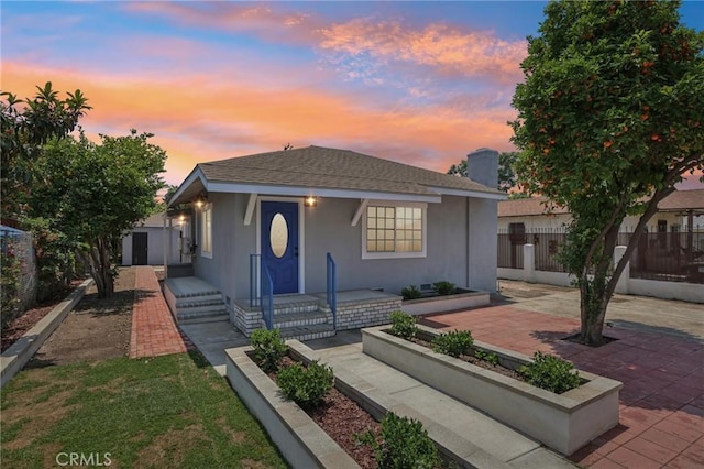 2422 E 115th St, Los Angeles, CA 90059 - view of front of house featuring a patio, stucco siding, and roof with shingles
