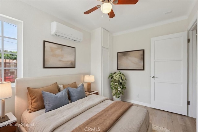 2422 E 115th St, Los Angeles, CA 90059 - bedroom featuring a wall mounted AC, light wood-type flooring, and a ceiling fan