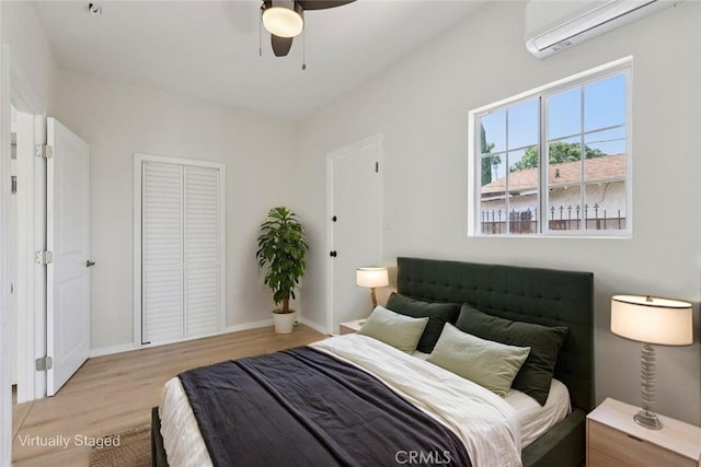 2422 E 115th St, Los Angeles, CA 90059 - bedroom with a wall mounted air conditioner, light wood-style flooring, a closet, and ceiling fan