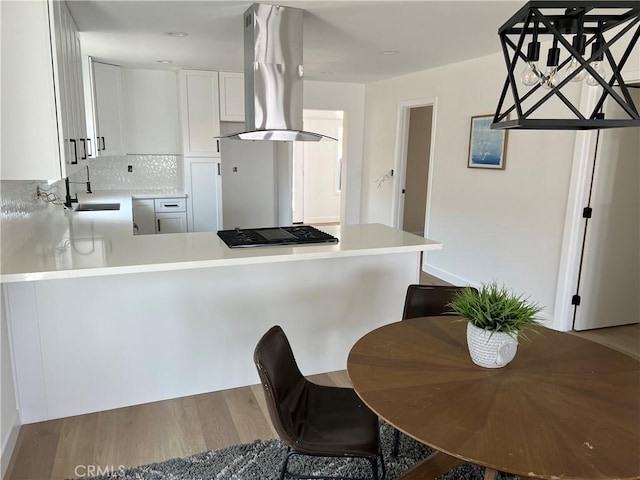 1350 Pleasant View Ave, Corona, CA 92882 - kitchen with island range hood, stainless steel gas stovetop, a peninsula, wood finished floors, and light countertops