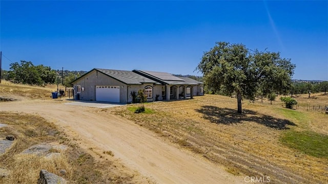 35095 Rough Rider Way, Raymond, CA 93653 - view of front facade with dirt driveway, roof mounted solar panels, and an attached garage