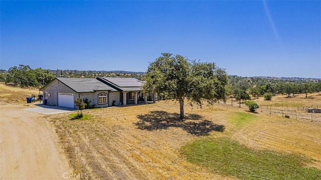 35095 Rough Rider Way, Raymond, CA 93653 - view of front of property featuring driveway, a garage, solar panels, and a view of countryside