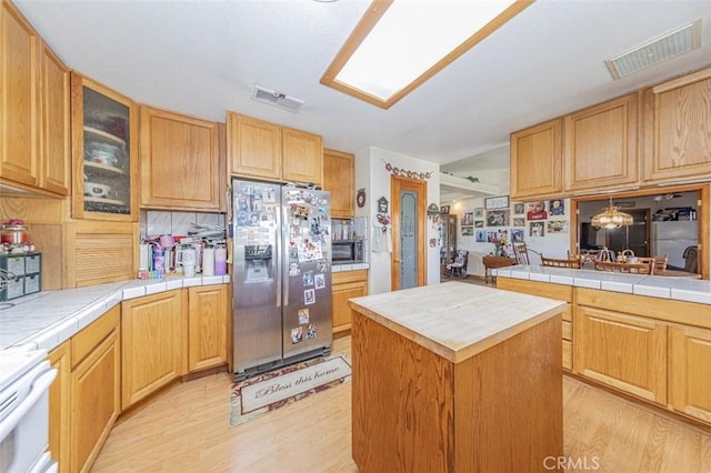 35095 Rough Rider Way, Raymond, CA 93653 - kitchen with stainless steel appliances, light wood finished floors, glass insert cabinets, a center island, and tile countertops