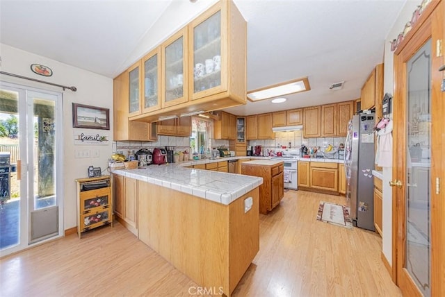 35095 Rough Rider Way, Raymond, CA 93653 - kitchen featuring appliances with stainless steel finishes, light wood finished floors, backsplash, a peninsula, and vaulted ceiling
