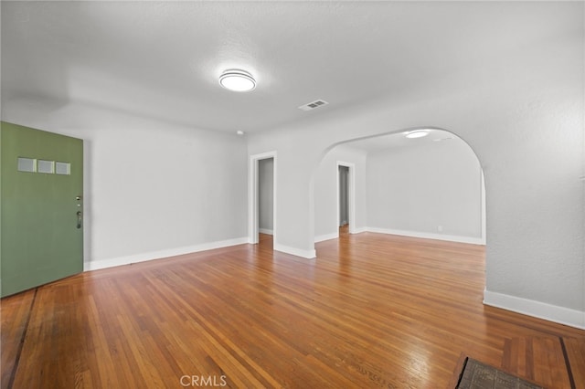12950 7th St, Chino, CA 91710 - unfurnished living room featuring arched walkways and wood finished floors