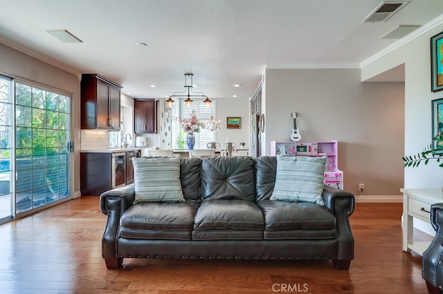 24813 Sagecrest Cir, Stevenson Ranch, CA 91381 - living room with wood finished floors, recessed lighting, ornamental molding, and beverage cooler