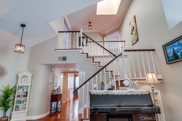 24813 Sagecrest Cir, Stevenson Ranch, CA 91381 - stairs featuring wood finished floors, a high ceiling, and a skylight
