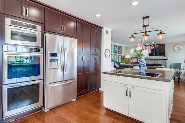 24813 Sagecrest Cir, Stevenson Ranch, CA 91381 - kitchen featuring stainless steel appliances, ornamental molding, open floor plan, light wood finished floors, and dark countertops