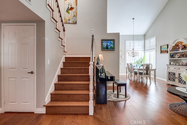 24813 Sagecrest Cir, Stevenson Ranch, CA 91381 - stairs with high vaulted ceiling, a chandelier, and wood finished floors