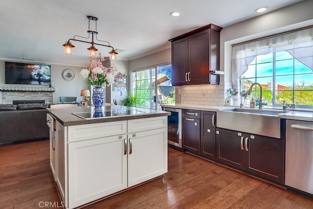 24813 Sagecrest Cir, Stevenson Ranch, CA 91381 - kitchen featuring dishwasher, black electric stovetop, dishwashing machine, crown molding, and a stone fireplace
