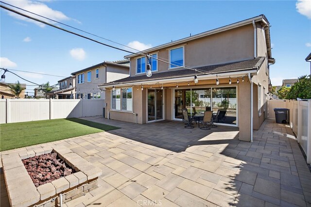 531 Owens River Dr, Oxnard, CA 93036 - rear view of house with stucco siding, a patio area, an outdoor fire pit, and a fenced backyard