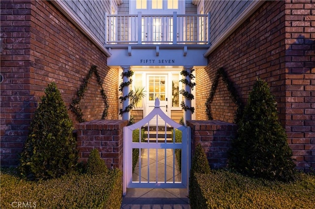 57 Cape Andover, Newport Beach, CA 92660 - property entrance with a balcony, brick siding, and a gate