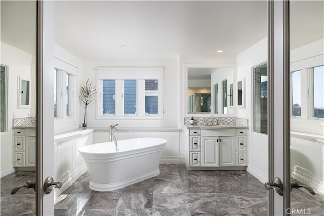 57 Cape Andover, Newport Beach, CA 92660 - bathroom featuring vanity, a freestanding bath, decorative backsplash, marble tiled flooring, and recessed lighting