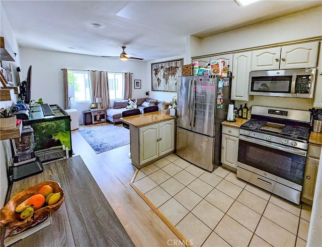 4216 Dalton Ave, Los Angeles, CA 90062 - kitchen featuring stainless steel appliances, a peninsula, open floor plan, a ceiling fan, and light wood-style flooring