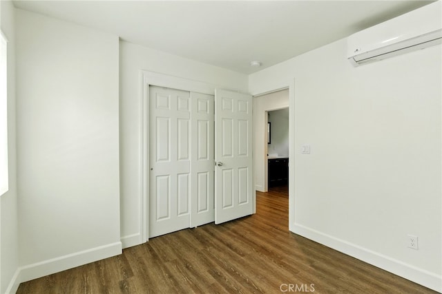 4041 57th St, Sacramento, CA 95820 - unfurnished bedroom with a wall unit AC, dark wood-style flooring, and a closet