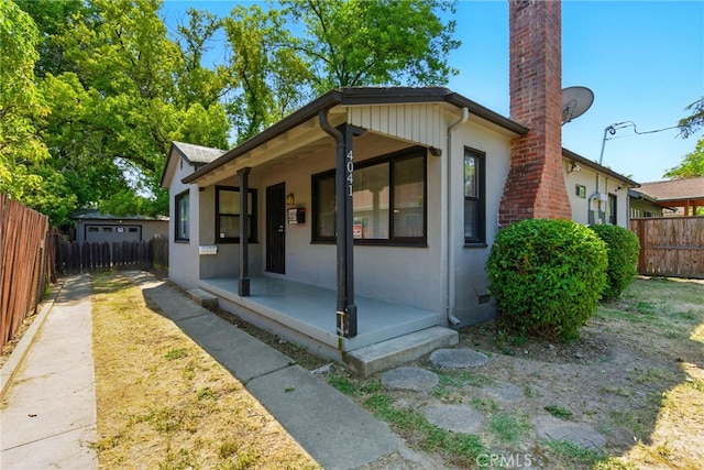 4041 57th St, Sacramento, CA 95820 - view of front of property with stucco siding, a chimney, and covered porch