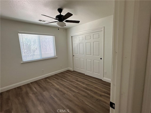 899 La Jolla Way, Merced, CA 95348 - unfurnished bedroom featuring dark wood-type flooring, a closet, ceiling fan, and a textured ceiling