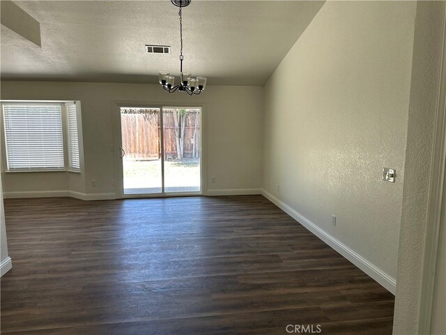 899 La Jolla Way, Merced, CA 95348 - unfurnished dining area with a chandelier, dark wood-style floors, a textured ceiling, and a textured wall