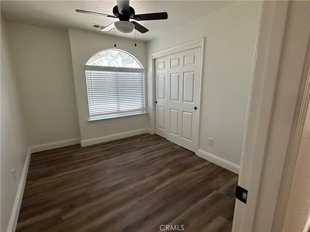 899 La Jolla Way, Merced, CA 95348 - unfurnished bedroom with dark wood-style floors, a closet, and a ceiling fan
