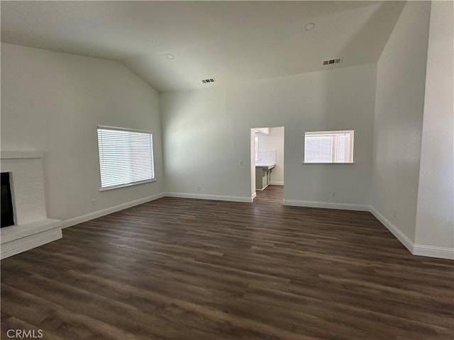 899 La Jolla Way, Merced, CA 95348 - unfurnished living room featuring plenty of natural light, vaulted ceiling, dark wood-type flooring, and a fireplace