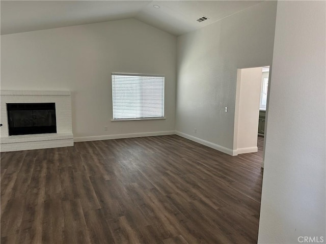 899 La Jolla Way, Merced, CA 95348 - unfurnished living room featuring dark wood finished floors, lofted ceiling, and a brick fireplace
