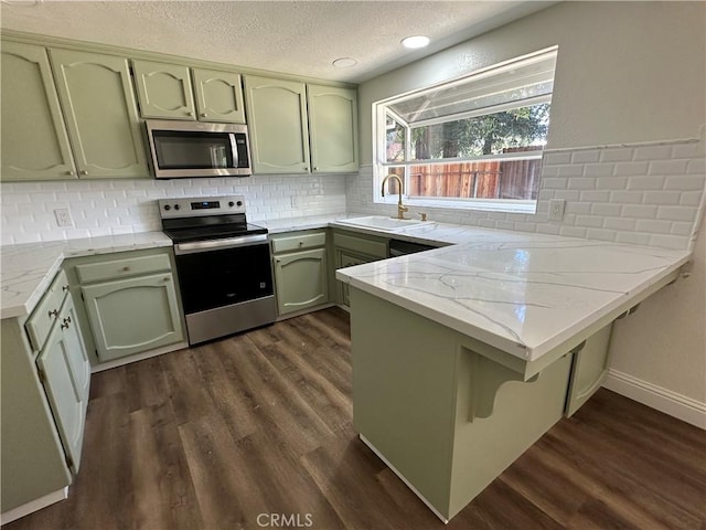 899 La Jolla Way, Merced, CA 95348 - kitchen with stainless steel appliances, green cabinets, a peninsula, a textured ceiling, and dark wood-style flooring
