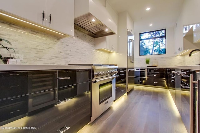 940 Burleigh Dr, Pasadena, CA 91105 - kitchen featuring custom exhaust hood, high end appliances, white cabinetry, decorative backsplash, and wood finished floors
