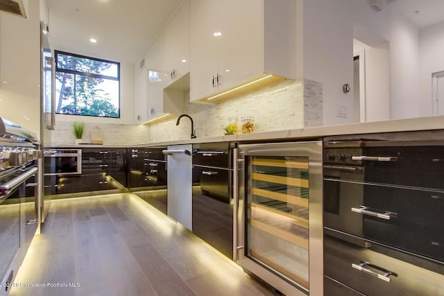 940 Burleigh Dr, Pasadena, CA 91105 - kitchen with beverage cooler, stainless steel countertops, white cabinetry, wood finished floors, and tasteful backsplash