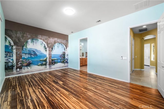 1706 Brittney Rd, Beaumont, CA 92223 - spare room featuring arched walkways and wood finished floors