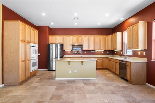 1706 Brittney Rd, Beaumont, CA 92223 - kitchen featuring stainless steel appliances, a center island, light brown cabinets, a breakfast bar area, and light countertops