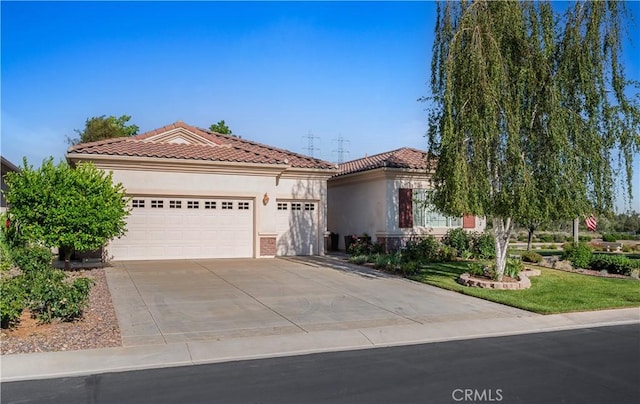1706 Brittney Rd, Beaumont, CA 92223 - mediterranean / spanish-style house with concrete driveway, an attached garage, stucco siding, and a tiled roof
