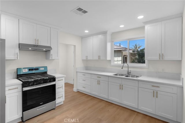 12815 Rexton St, Norwalk, CA 90650 - kitchen featuring stainless steel gas range, under cabinet range hood, white cabinetry, and recessed lighting