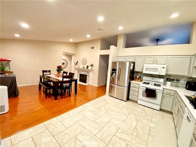 980 Lexington St, Hemet, CA 92545 - kitchen featuring white appliances, light countertops, tasteful backsplash, recessed lighting, and a fireplace