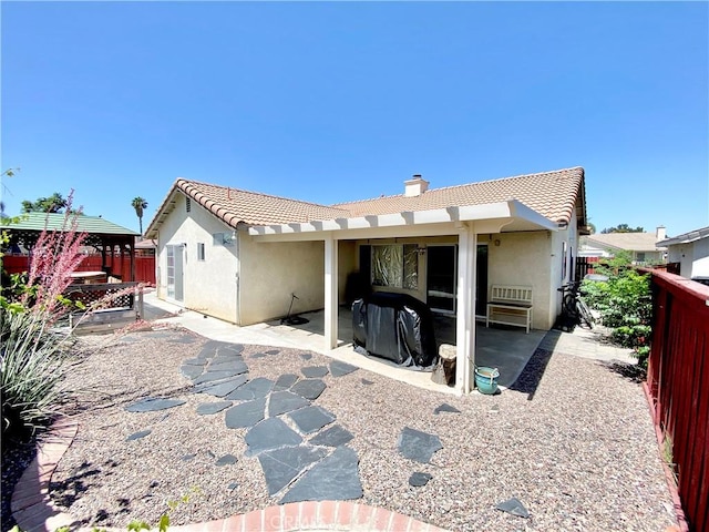980 Lexington St, Hemet, CA 92545 - back of property with stucco siding, a tile roof, a chimney, a fenced backyard, and a patio area