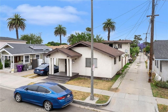 1045 E New York St, Long Beach, CA 90813 - view of front of house featuring stucco siding, solar panels, and concrete driveway