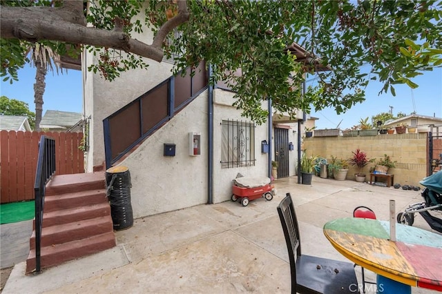 1045 E New York St, Long Beach, CA 90813 - view of side of home with stucco siding, a fenced backyard, and a patio area