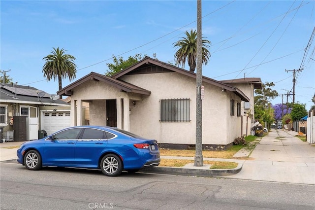 1045 E New York St, Long Beach, CA 90813 - bungalow-style house featuring stucco siding, a garage, and driveway