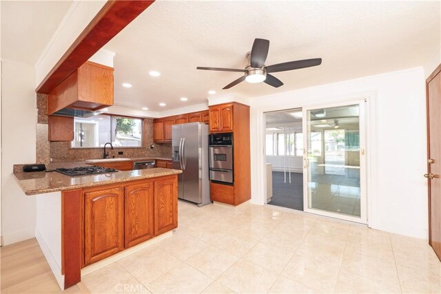 12711 Leroy Ave, Garden Grove, CA 92841 - kitchen with appliances with stainless steel finishes, a warming drawer, ceiling fan, a peninsula, and brown cabinetry