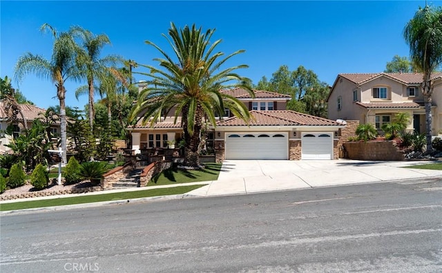 2417 Lenai Cir, Corona, CA 92879 - mediterranean / spanish house with an attached garage, concrete driveway, stone siding, and stucco siding