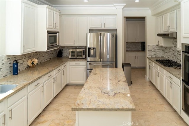 2417 Lenai Cir, Corona, CA 92879 - kitchen featuring appliances with stainless steel finishes, crown molding, under cabinet range hood, a kitchen island, and backsplash