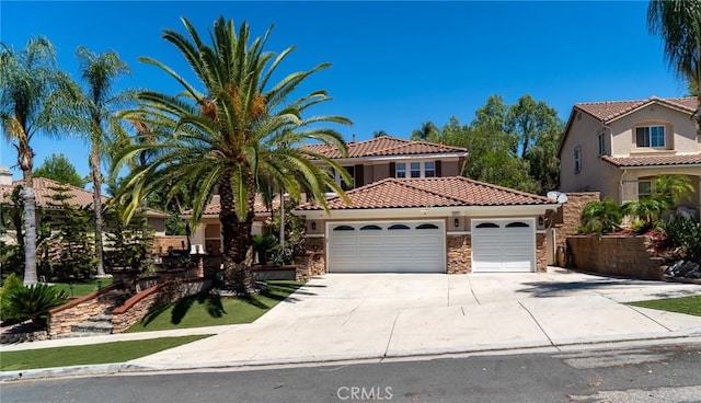 2417 Lenai Cir, Corona, CA 92879 - mediterranean / spanish house featuring an attached garage, a tiled roof, stone siding, driveway, and stucco siding