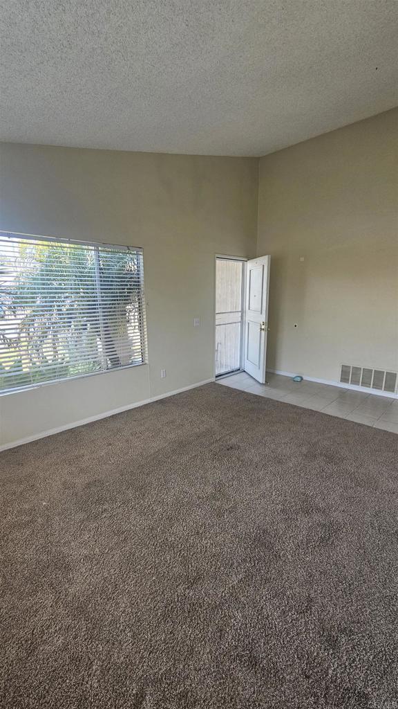 4028 Johnson Dr, Oceanside, CA 92056 - empty room with light carpet and a textured ceiling