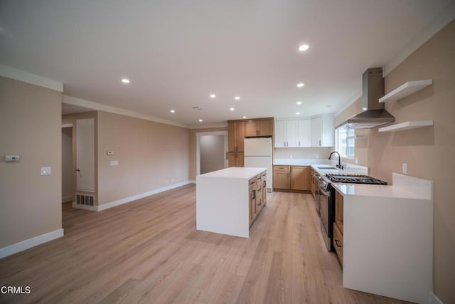 1100 Dahlia St, Oxnard, CA 93036 - kitchen with wall chimney range hood, stainless steel gas stove, freestanding refrigerator, a kitchen island, and open shelves