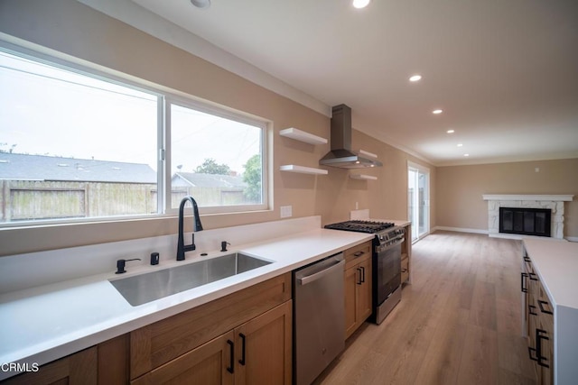 1100 Dahlia St, Oxnard, CA 93036 - kitchen with appliances with stainless steel finishes, wall chimney range hood, light wood finished floors, recessed lighting, and a fireplace