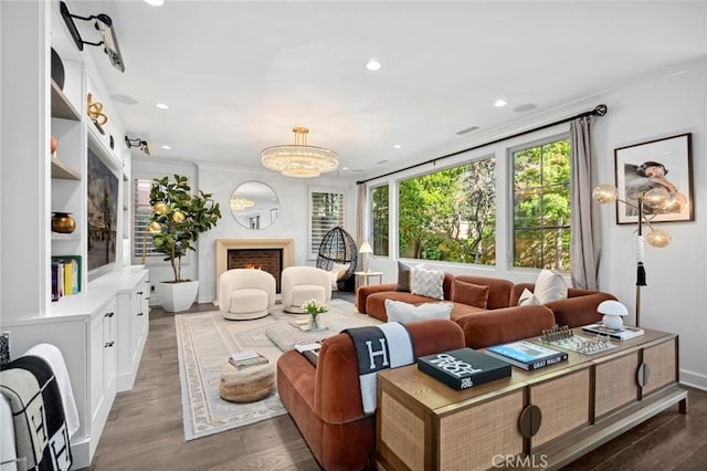 24 Tesoro, Irvine, CA 92618 - living room with crown molding, dark wood-type flooring, a warm lit fireplace, recessed lighting, and a chandelier