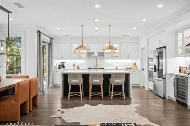 24 Tesoro, Irvine, CA 92618 - kitchen with wine cooler, light countertops, under cabinet range hood, glass insert cabinets, and crown molding