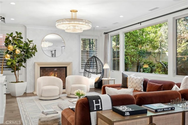 24 Tesoro, Irvine, CA 92618 - living area with crown molding, light wood-type flooring, recessed lighting, a lit fireplace, and a chandelier