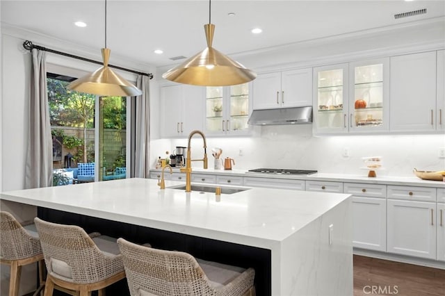24 Tesoro, Irvine, CA 92618 - kitchen with under cabinet range hood, dark wood-type flooring, white cabinetry, light countertops, and recessed lighting