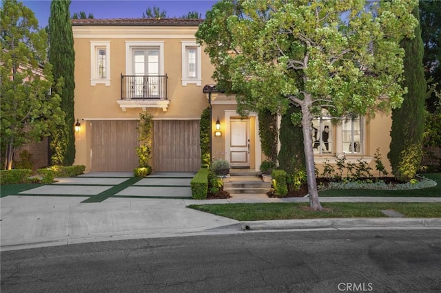 24 Tesoro, Irvine, CA 92618 - view of front of home featuring a balcony, concrete driveway, an attached garage, and stucco siding