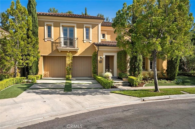24 Tesoro, Irvine, CA 92618 - view of front of property featuring a balcony, a garage, driveway, a tiled roof, and stucco siding